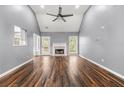 Open living room with a fireplace, vaulted ceiling, fan, wood-look floors, and neutral paint at 113 Willow Hill Ln, Stockbridge, GA 30281