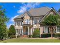 Close-up of the home showcasing the columned front porch, arched window, and manicured landscaping at 19 Troup Ct, Acworth, GA 30101
