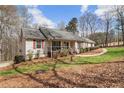 Quaint single-story home with wood porch and walkway with verdant landscaping at 4150 E East Chapel Hill Rd, Douglasville, GA 30135