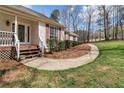 Inviting front porch with fresh landscaping that leads to a glass-paneled front door at 4150 E East Chapel Hill Rd, Douglasville, GA 30135