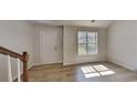 Living room features hardwood floors, a large window, and a view of the staircase at 450 Pebble Blvd, Covington, GA 30016