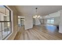 Bright, open-concept living room with hardwood floors, modern chandelier, and large picture window at 450 Pebble Blvd, Covington, GA 30016