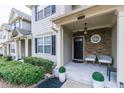 Inviting covered porch with elegant stone accents, stylish seating, and decorative plants at 2449 Suwanee Pointe Dr, Lawrenceville, GA 30043