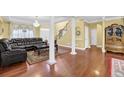 Open-concept living room with hardwood floors, decorative columns, and a staircase at 1621 Telfair Chase Way, Lawrenceville, GA 30043