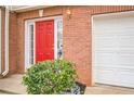 A bright red front door, brick facade, and attached garage create a welcoming entryway at 3302 Waldrop Trl, Decatur, GA 30034