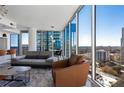 Bright living space with floor-to-ceiling windows offering stunning cityscape views, a modern sofa and arm chair at 1080 Peachtree Ne St # 1610, Atlanta, GA 30309