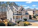 Beautiful two-story home featuring brick and gray siding, complemented by mature landscaping at 1775 Unity Loop, Cumming, GA 30040