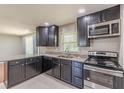 Modern kitchen features stainless steel appliances, dark cabinets, and granite countertops at 1157 Helen St, Morrow, GA 30260
