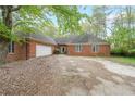 Charming brick home featuring an attached garage and a well-kept lawn, offering a classic suburban appeal at 4367 S Berkeley Lake Nw Rd, Duluth, GA 30096