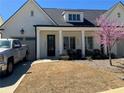 Charming home with white columns, a well-manicured lawn, and a blooming tree at 5099 Noble Village Way, Lilburn, GA 30047
