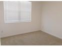 Bright bedroom featuring neutral carpet, blinds, and fresh paint at 120 Montgomery Dr, Stockbridge, GA 30281
