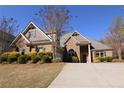Attractive brick home with stone accents, complemented by a well-manicured lawn and mature trees at 1520 Camden Cove Dr, Cumming, GA 30040