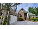 Beautiful brick home with a two-car garage, complemented by lush greenery and a well-maintained driveway at 1520 Camden Cove Dr, Cumming, GA 30040