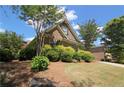 The exterior features lush landscaping and a brick facade, complemented by mature trees and green lawn at 1520 Camden Cove Dr, Cumming, GA 30040
