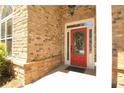 Close-up of the entryway, showing the red front door with decorative glass, set in a brick facade at 1520 Camden Cove Dr, Cumming, GA 30040