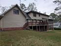 Exterior view of the home showcasing a large backyard, deck, and screened-in porch at 3015 Ascot Ln, Roswell, GA 30076