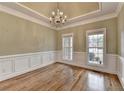 Bright dining room showcasing hardwood floors, tray ceiling, and natural light through large windows at 3426 Olivia Grace Way, Dacula, GA 30019