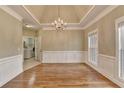 Spacious dining room with hardwood floors, decorative molding, and modern chandelier at 3426 Olivia Grace Way, Dacula, GA 30019