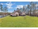 Brick two-story home with manicured lawn and mature trees on a sunny day at 180 Allie Dr, Mcdonough, GA 30252