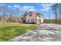 A two-story brick house with a long drive, a well-kept lawn, and mature trees at 180 Allie Dr, Mcdonough, GA 30252