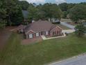 Well-maintained single-story red brick home with a lush lawn and manicured landscaping at 3020 Templeton Ln, Loganville, GA 30052