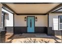 Inviting front porch showcasing a blue door with glass paneling, black brick, and sconce lighting at 131 Scruggs Ne Ct, Atlanta, GA 30307