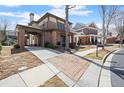 View of the brick home featuring a covered driveway, landscaped yard, and neighborhood street at 1917 Baxley Pine Trce, Suwanee, GA 30024