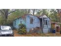 Exterior view of a distressed, light blue one-story home at 1182 Bronx Nw St, Atlanta, GA 30314