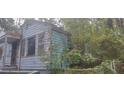 Exterior view of a distressed, light blue one-story home at 1182 Bronx Nw St, Atlanta, GA 30314