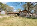 Single-story home with brick and stone and a well-maintained lawn, plus a side garage at 1254 Renee Dr, Decatur, GA 30035