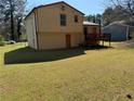 View of the home's exterior featuring a fenced backyard, a small deck, and an unfinished basement entry at 1848 San Gabriel Ave, Decatur, GA 30032