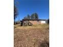 Exterior view of the brick home showcasing a wooden deck and spacious backyard at 2103 River Rd, Ellenwood, GA 30294