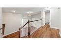 Bright staircase leading to a hardwood floored landing with half-bath and doorway at 3480 Hogan Sw Rd, Atlanta, GA 30331