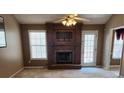 A living room with a dark fireplace, a ceiling fan, and views to the outdoor deck at 210 Vintage Dr, Covington, GA 30014