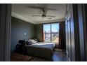 Small bedroom with dark accent wall, a window that looks out on city buildings and modern ceiling fan at 401 16Th Nw St # 1463, Atlanta, GA 30363