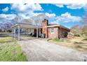 Cozy brick home with a covered carport and plenty of parking space on a sunny day at 1715 Highway 11 N, Social Circle, GA 30025