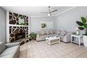 Spacious living room featuring tiled flooring, a stone fireplace, and neutral gray walls for a modern aesthetic at 3776 Bromolow Trl, Lawrenceville, GA 30044