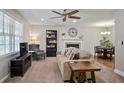 Inviting living room with neutral paint, plush carpet, a cozy fireplace, and ample natural light from the large window at 5095 Derry Nw Rd, Acworth, GA 30101