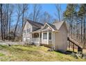 An exterior side view showcasing the yard, deck, stairs, and access to a crawl space under the house at 321 Oak Landing Cir, Douglasville, GA 30134