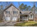 Charming two-story home with a front porch and a two-car garage and tan siding and shutters at 321 Oak Landing Cir, Douglasville, GA 30134