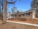 Brick home exterior featuring a welcoming porch and a well-maintained yard at 121 Northwoods Rd, Sharpsburg, GA 30277