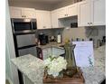 Bright kitchen with white cabinets, stainless steel appliances, granite countertops, and modern fixtures at 215 Piedmont Ne Ave # 2205, Atlanta, GA 30308