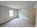 Bright, carpeted bedroom with a window offering natural light and neutral wall color at 2654 Mourning Dove Drive (Lot 39), Grayson, GA 30017