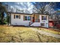 Beautifully renovated home showcasing striking wood shutters and a vibrant red front door, enhancing its curb appeal at 1238 Westboro Sw Dr, Atlanta, GA 30310