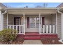 Covered front porch featuring classic white columns and a red painted floor and steps at 3645 Fay Dr, Rex, GA 30273