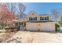 Beautiful yellow two-story home with blue shutters, front porch, and a spacious two-car garage at 45 Somerset Ct, Covington, GA 30016