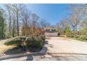 Two-story yellow home with blue shutters, surrounded by greenery, featuring a spacious driveway at 45 Somerset Ct, Covington, GA 30016