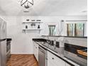 Well-lit kitchen featuring stainless steel appliances, dark countertops, and open shelving at 2024 Oakley Se Trce, Smyrna, GA 30080