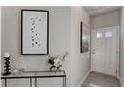 Tastefully decorated hallway with console table, art, floral arrangement, and a white front door at 5185 Longview Run, Decatur, GA 30035