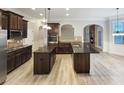 Spacious kitchen features granite countertops, dark wood cabinets, double islands, and stainless steel appliances at 2897 Austin Common Dr, Dacula, GA 30019